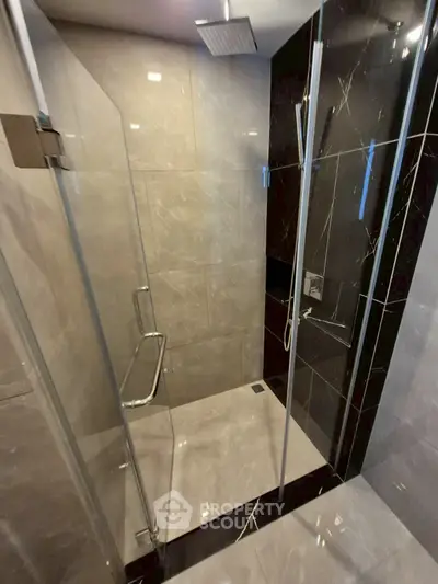 Modern bathroom with sleek glass shower enclosure and elegant tile design.