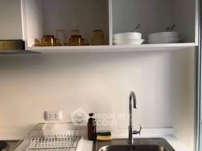 Modern kitchen with sleek sink and open shelving, perfect for minimalist living.