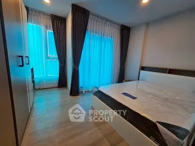 Modern bedroom with large windows and stylish curtains in a contemporary apartment.