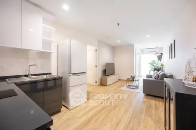 Modern open-plan living room and kitchen with sleek design and natural light