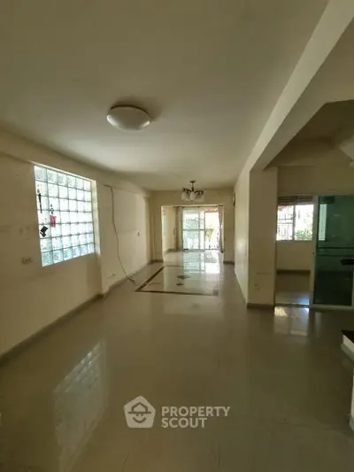 Spacious living room with large windows and natural light, perfect for family gatherings.