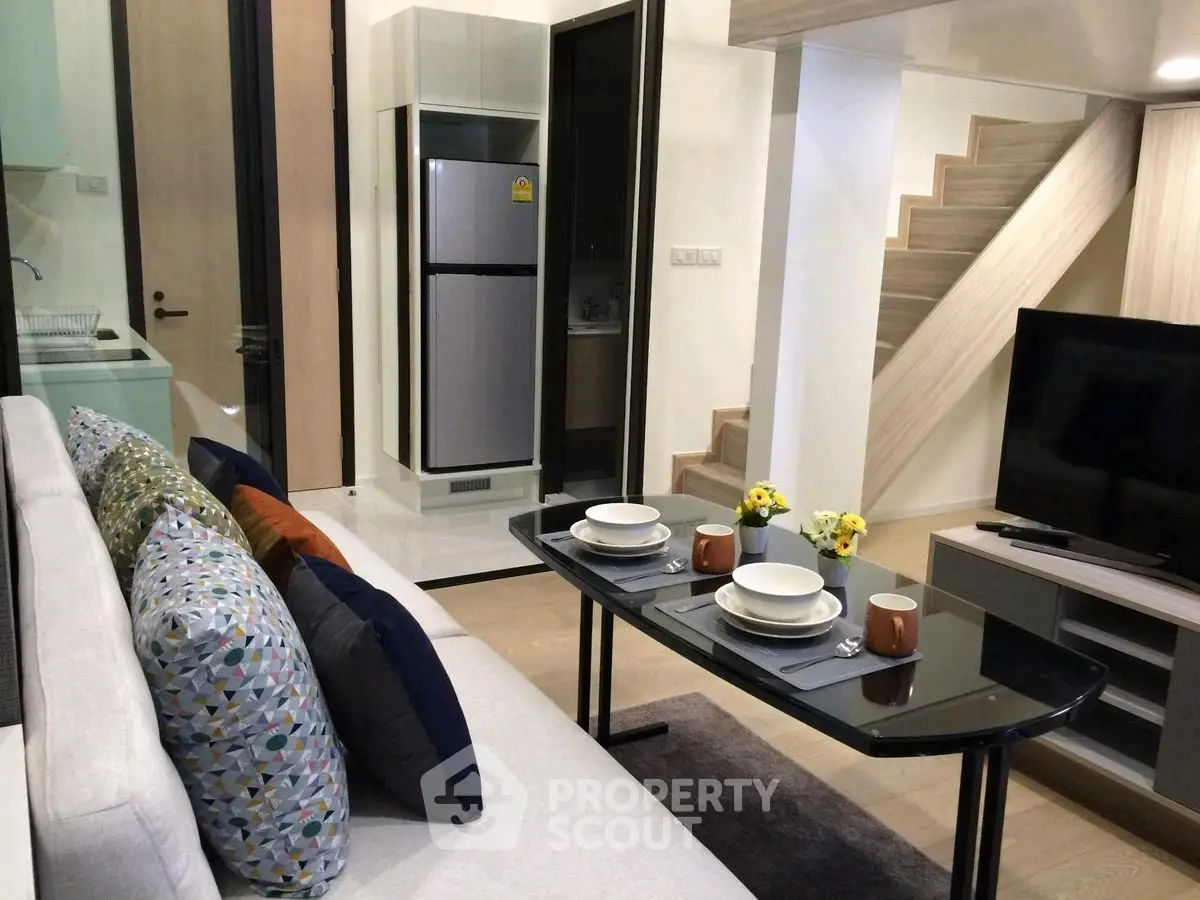 Modern living room with stylish decor and open kitchen layout in a contemporary apartment.