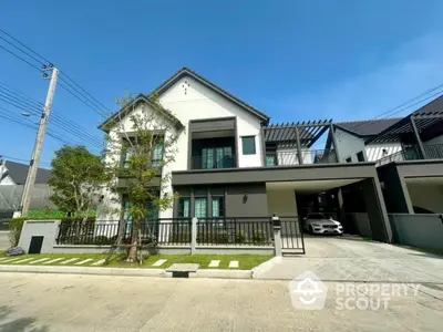 Modern two-story house with sleek design and spacious driveway in suburban neighborhood.