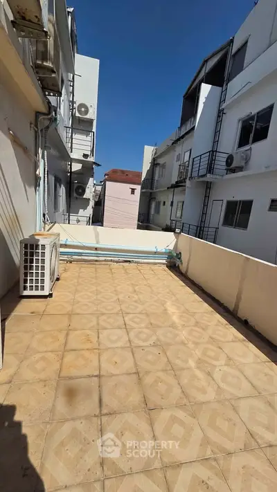 Spacious balcony with tiled flooring and urban view, perfect for outdoor relaxation.