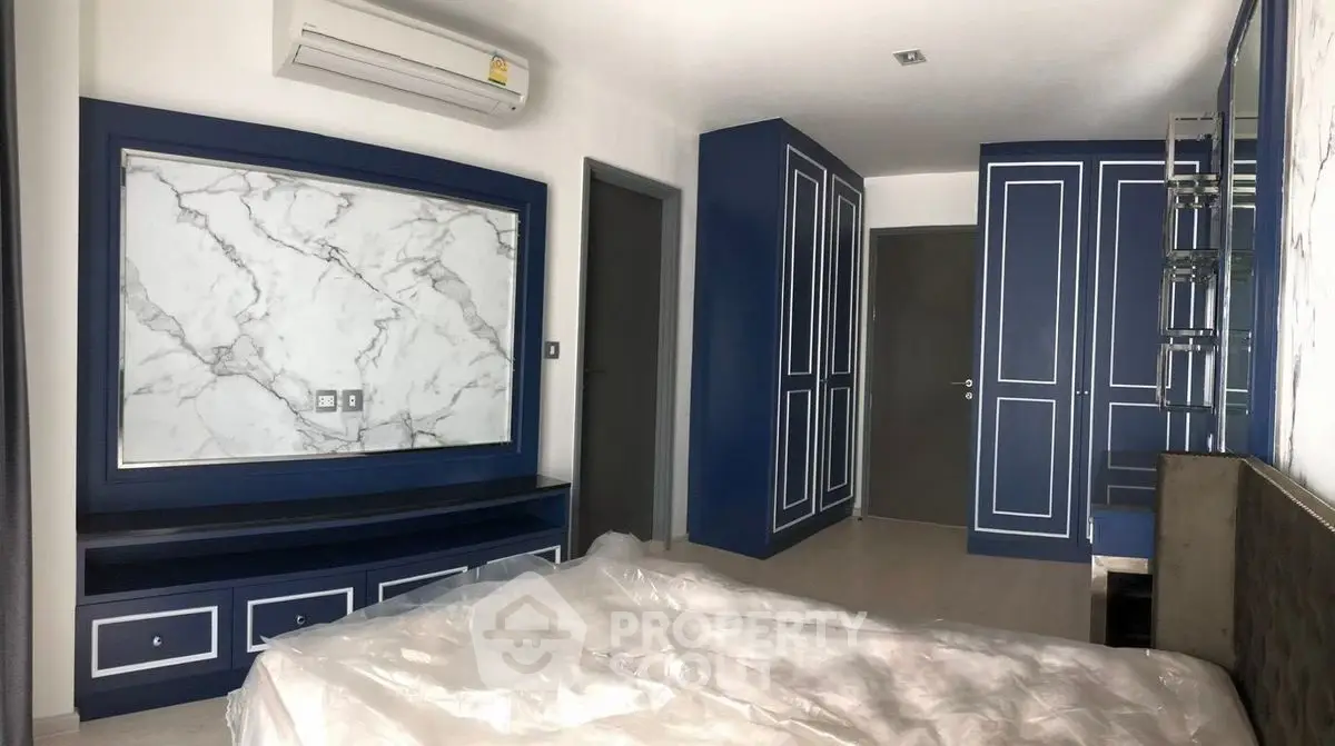 Modern bedroom with blue accents and marble wall paneling