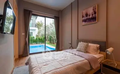 Luxurious bedroom with pool view, modern decor, and large window for natural light.