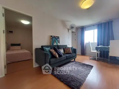 Cozy living room with modern decor and adjacent bedroom in a stylish apartment.