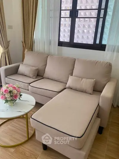 Cozy living room with beige sofa and elegant curtains, perfect for relaxation.