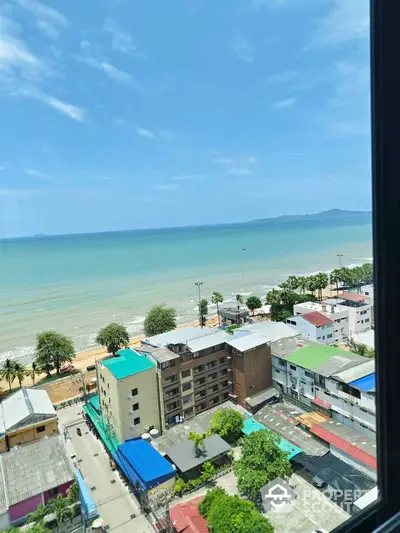 Stunning ocean view from high-rise building overlooking beach and cityscape.