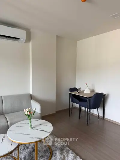 Modern living room with stylish furniture and air conditioning, featuring a cozy dining area and elegant decor.