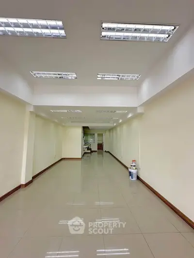 Spacious commercial space with bright lighting and tiled flooring, ideal for retail or office setup.