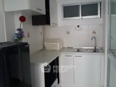 Compact kitchen with modern white cabinets and sleek countertop