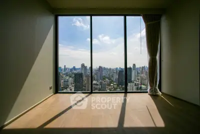 Stunning city view from high-rise apartment with floor-to-ceiling windows and wooden flooring.