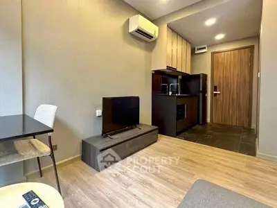 Modern living room with sleek design, featuring a compact kitchen and stylish furniture in a cozy apartment.