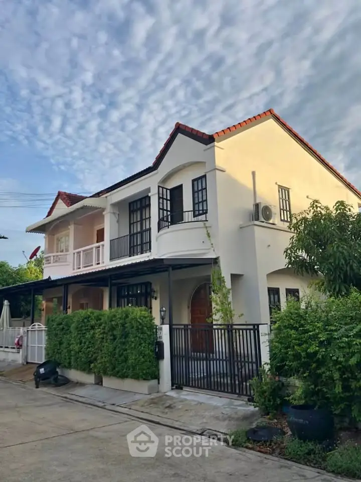 Charming two-story house with lush greenery and modern design in a serene neighborhood.