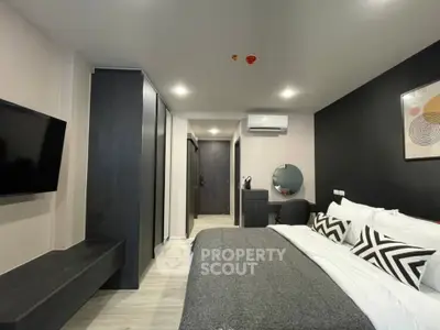 Modern bedroom with sleek design, featuring a comfortable bed, wall-mounted TV, and stylish decor.