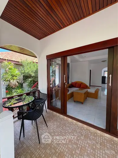 Charming patio with cozy seating and garden view, perfect for relaxation and entertaining guests.