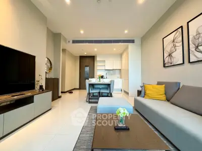 Modern living room with open kitchen, stylish decor, and cozy seating area in a contemporary apartment.
