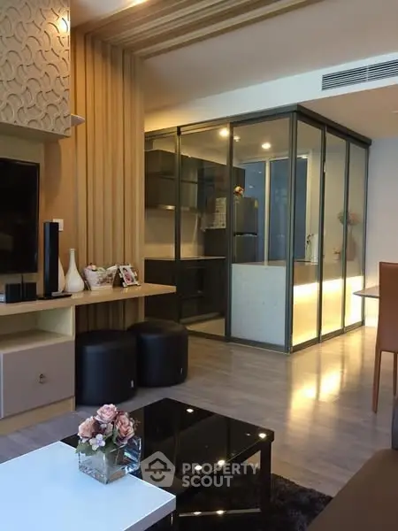 Modern living room with glass-enclosed kitchen and stylish decor