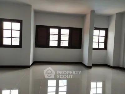 Spacious empty room with large windows and glossy tiled floor, perfect for customization.