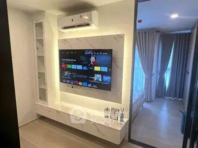 Modern living room with sleek TV setup and view into cozy bedroom