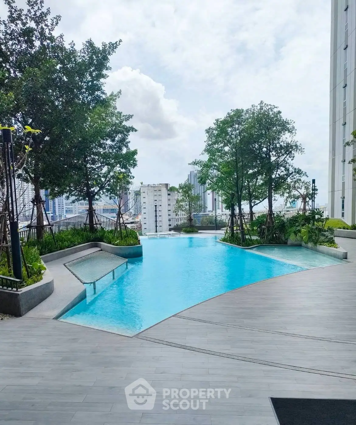 Luxurious rooftop pool with stunning city views and lush greenery, perfect for relaxation and leisure.