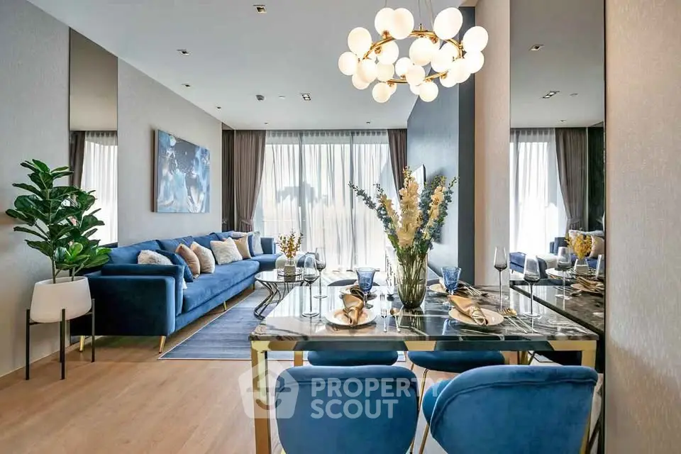 Luxurious modern living room with elegant dining area and stylish blue decor.
