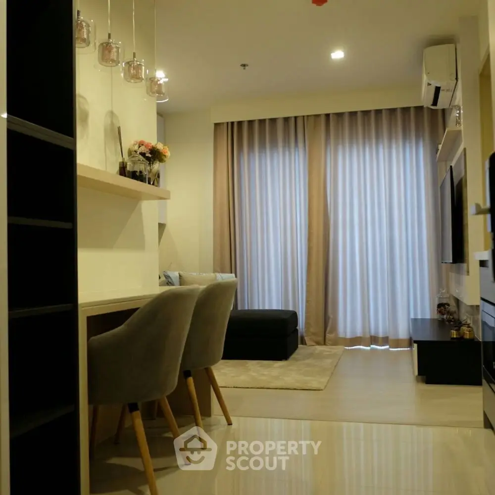 Modern living room with elegant decor and cozy seating area, featuring large windows and stylish lighting.