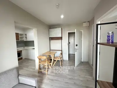 Modern open-plan living room with dining area and kitchen in contemporary apartment.