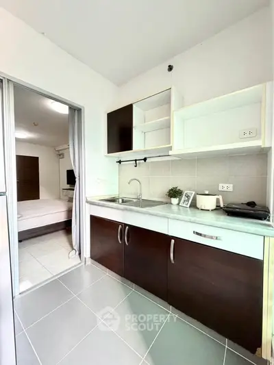 Modern kitchen with sleek cabinetry and open layout adjacent to a cozy bedroom.