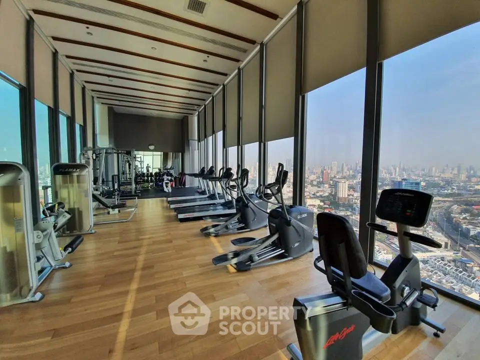 Luxurious high-rise gym with panoramic city views and modern fitness equipment.