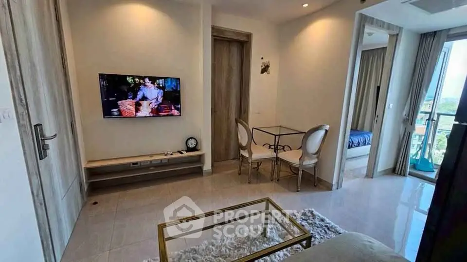 Modern living room with TV, glass table, and balcony view in stylish apartment.