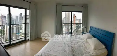 Spacious bedroom with stunning city view and large windows in modern apartment.