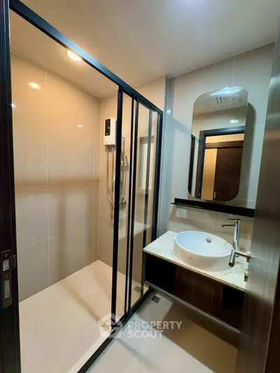 Modern bathroom with sleek shower and stylish vanity in contemporary apartment.