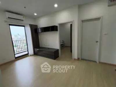 Spacious modern living room with balcony and sleek flooring in urban apartment.