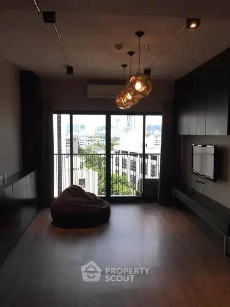 Modern living room with large windows and city view, featuring stylish lighting and minimalist decor.