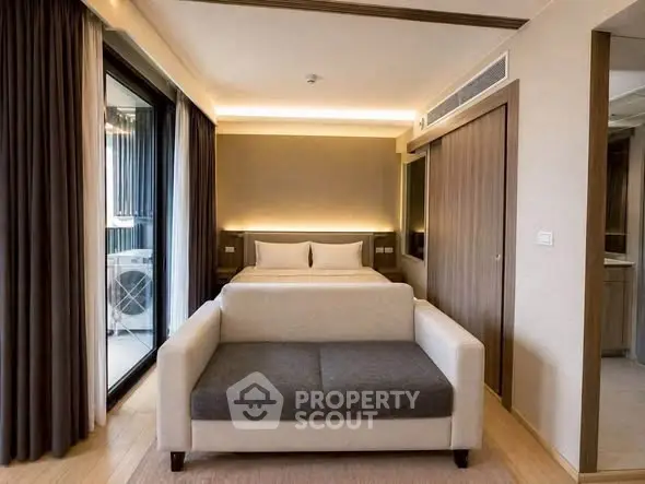 Modern bedroom with cozy sofa and balcony view in luxury apartment