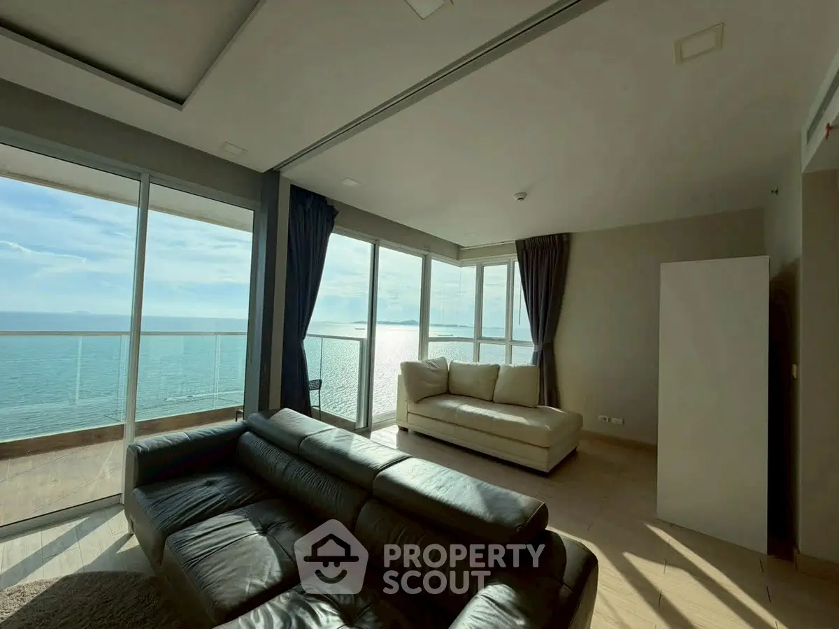 Luxurious corner unit living room with stunning ocean view and modern leather sofas.