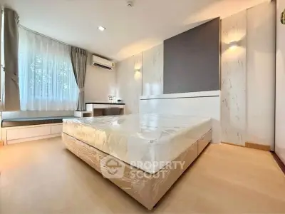 Spacious bedroom with modern decor and large window in a stylish apartment