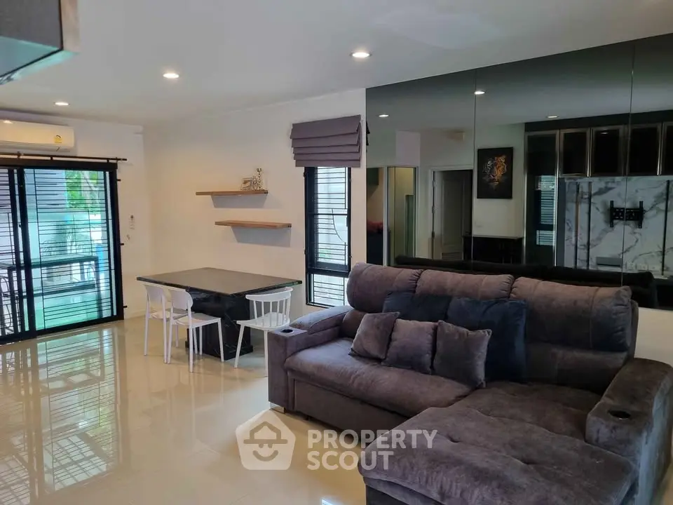 Modern living room with plush sofa and mirrored wall in stylish apartment