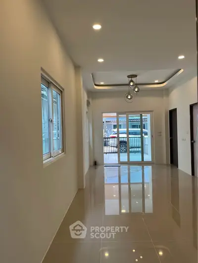 Spacious modern living room with glossy tiled floors and stylish lighting, perfect for family gatherings.
