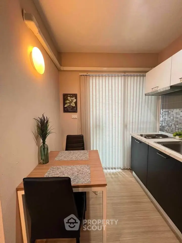 Modern kitchen with sleek design and dining area, featuring natural light and stylish decor.