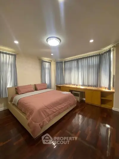 Spacious bedroom with elegant hardwood floors and ample natural light