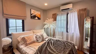 Cozy bedroom with elegant decor and natural light, featuring plush bedding and stylish curtains.
