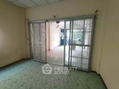Spacious room with sliding glass doors leading to a bright balcony area.