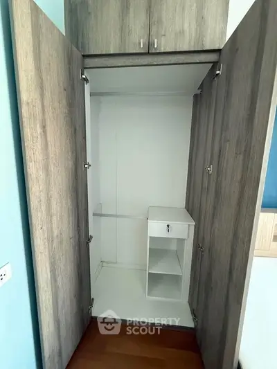 Spacious built-in wardrobe with modern wood finish and ample storage space.