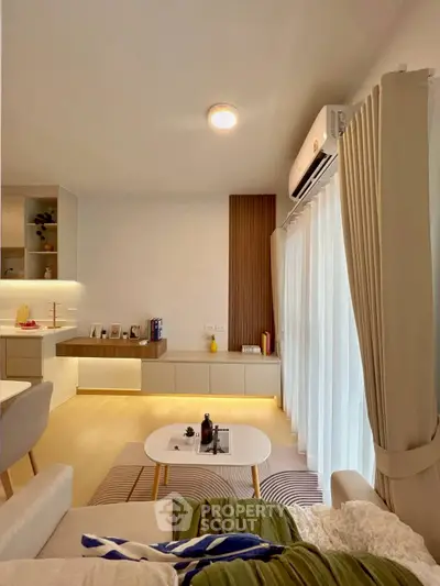Modern living room with stylish decor and natural light, featuring a cozy seating area and elegant shelving.