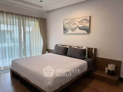 Modern bedroom with large window and stylish decor in a cozy apartment.