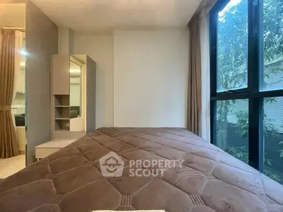 Cozy bedroom with large window and modern furnishings