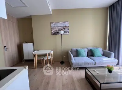 Modern living room with cozy sofa, stylish decor, and dining area in open layout apartment.